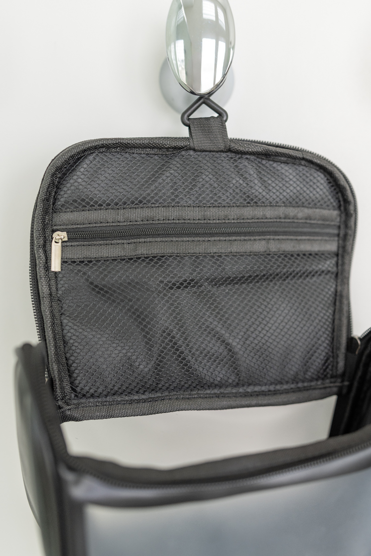 The clear hanging toiletry bag features a top zippered pocket for added organization.