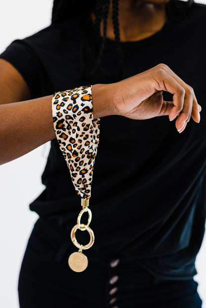 A woman wearing all black wearing a Modern + Chic Luna Fabric Keychain Bracelet for Women around her wrist.