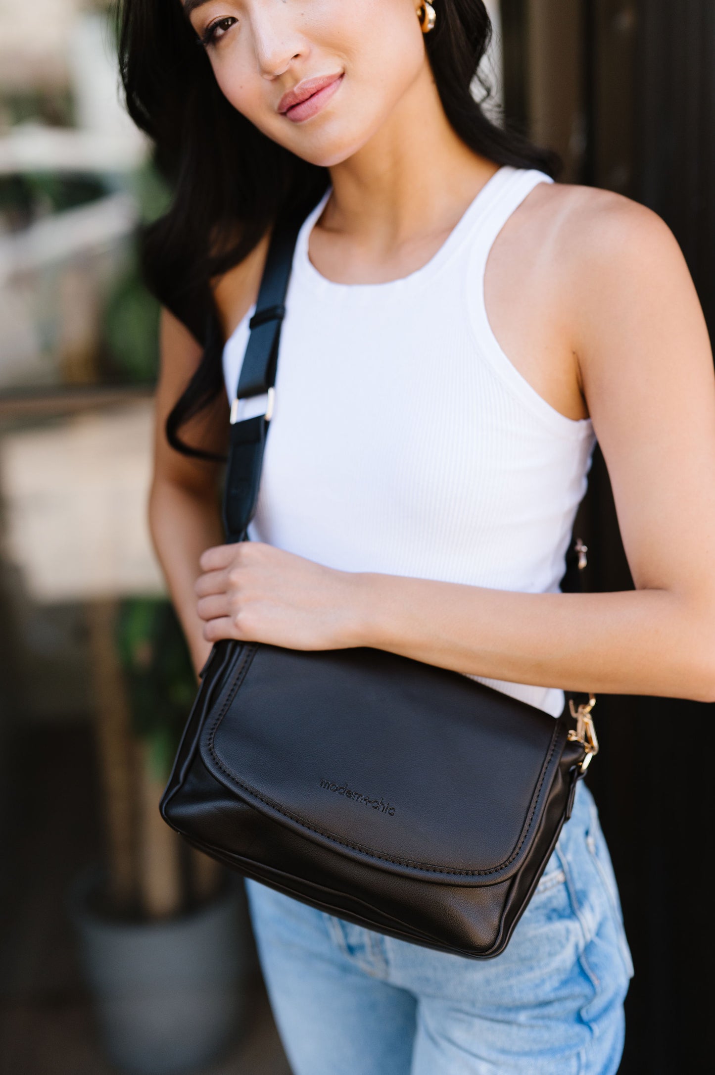 A woman wearing a black crossbody.