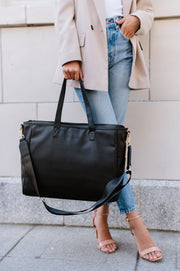 A woman holding a black tote.