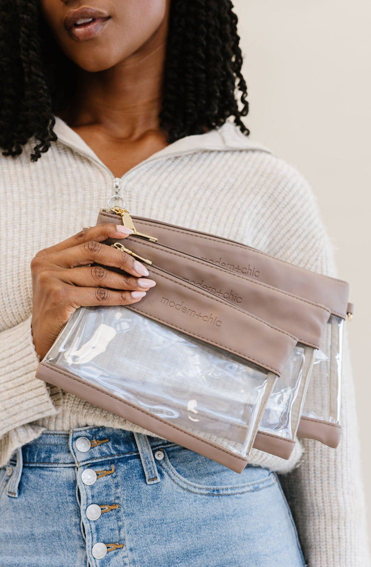 A woman holding a set of three clear bags.