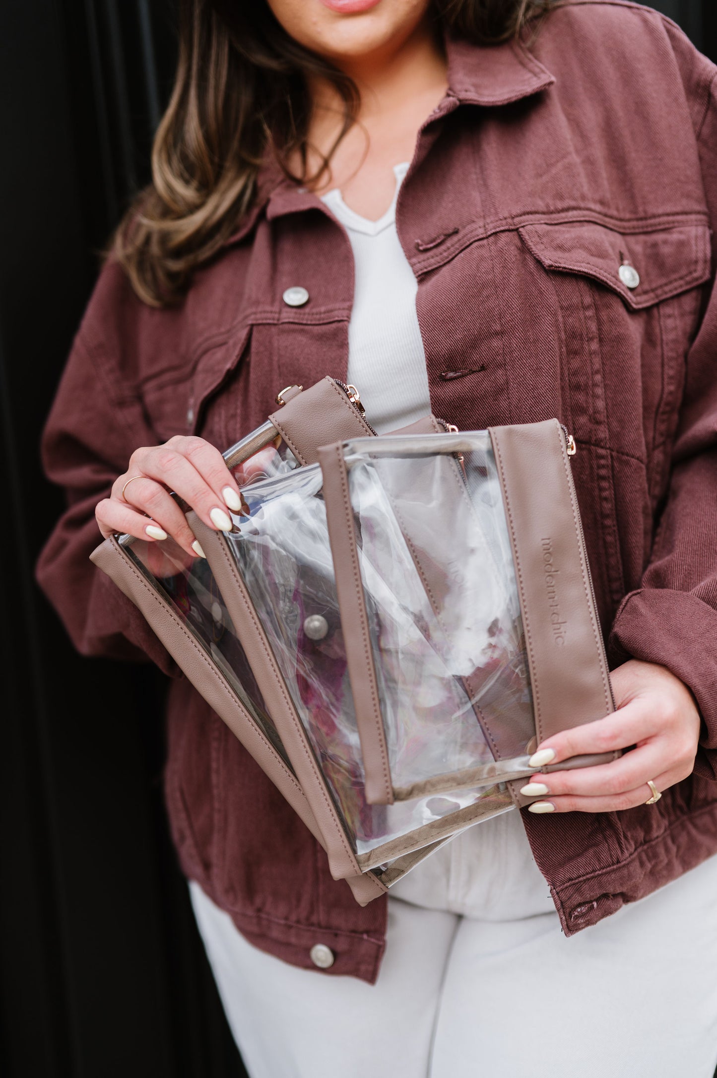 A woman holding a set of three clear bags.