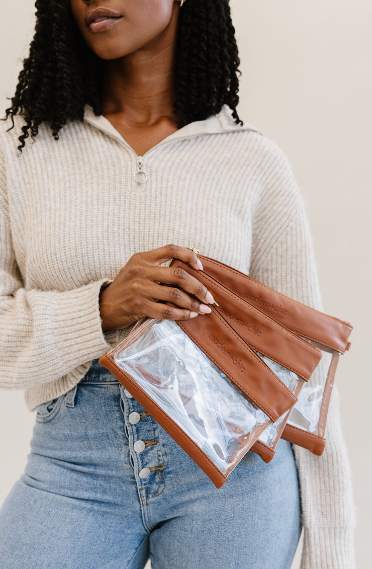 A woman holding brown vegan leather and clear PV pouches.