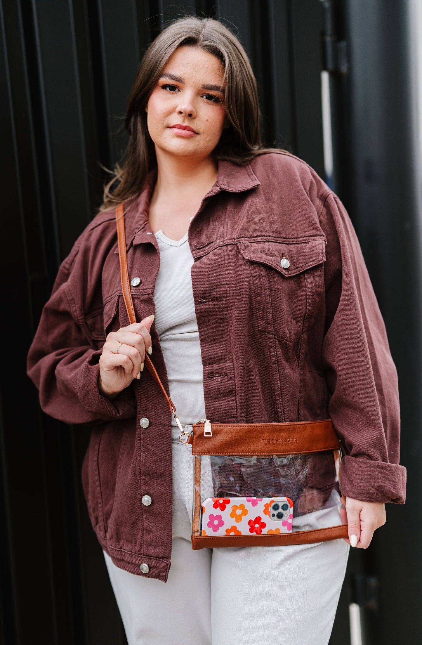A woman wearing a brown and clear crossbody bag.