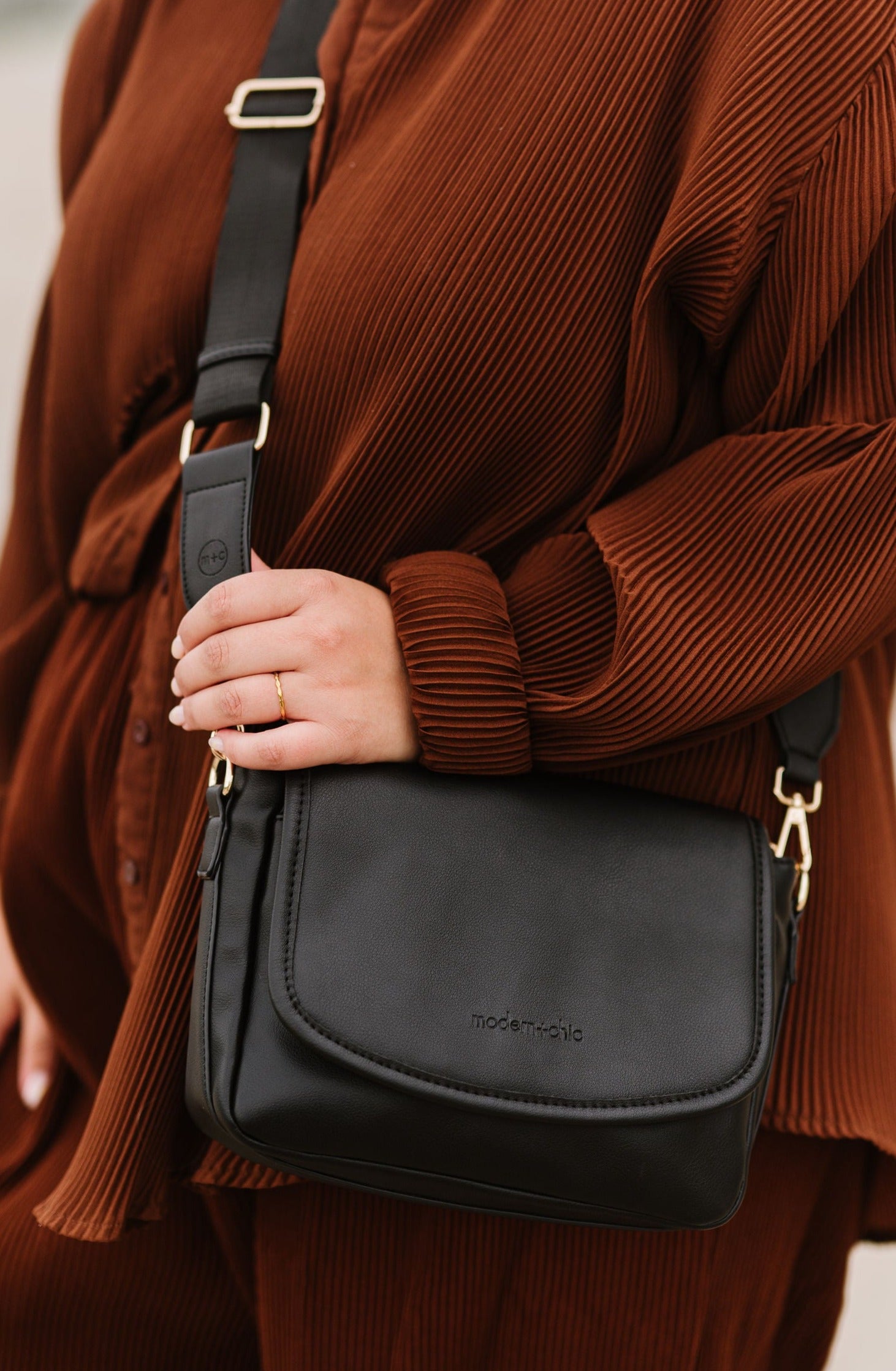 A woman wearing a black crossbody bag.