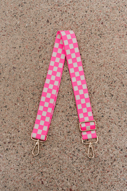 Hot pink and white Modern + Chic Lizzie Checkered Purse Strap for Crossbody Bags on a speckled background.