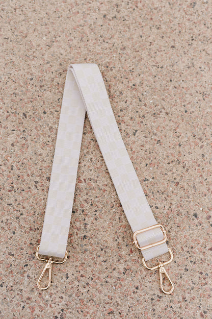 White on white Modern + Chic Lizzie Checkered Purse Strap for Crossbody Bags on a speckled background.