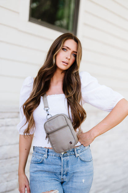 Woman wearing a white top, jeans and a grey Modern + Chic Lainey Convertible Crossbody Bag for Women crossbody.