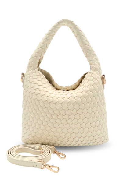 Cream colored woven handbag with a matching strap on a white background