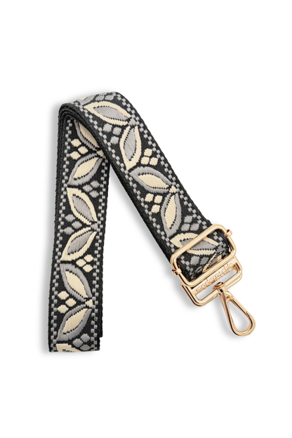 Decorative grey colored bag strap with a floral pattern and a gold clasp on a white background