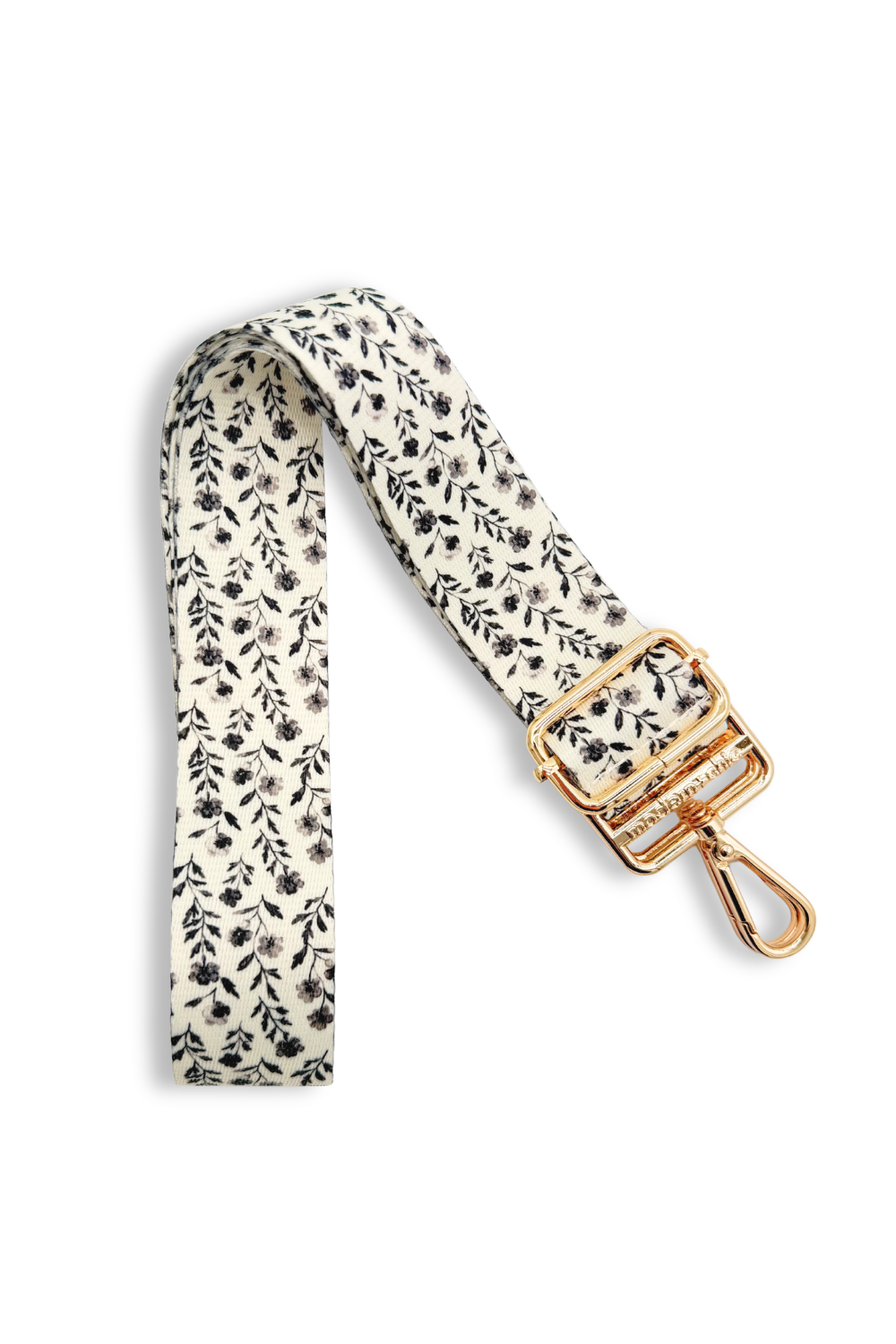Black and white floral-patterned strap with a gold clasp on a white background