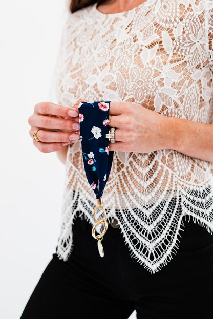 A woman holding a Modern + Chic Luna Fabric Keychain Bracelet for Women. 