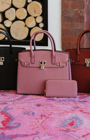 a mauve tote bag with gold hardware and a matching wallet 